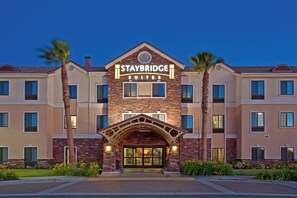 A Staybridge Suites hotel with a brick facade, multiple windows, and a central entrance. - Staybridge Suites Palmdale by IHG (Palmdale)