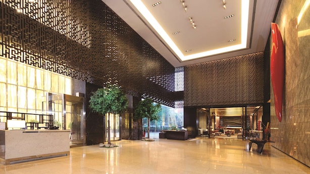 A spacious lobby with a reception desk, seating area, and a large red sculpture. - DoubleTree by Hilton Beijing (Beijing)