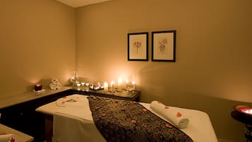 Relax in a serene space with a massage table, towels, and a soothing ambiance.