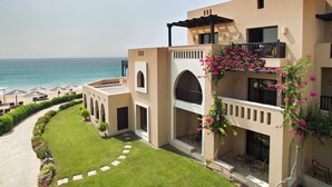 Un hotel con piscina, mobiliario exterior y vistas al mar.