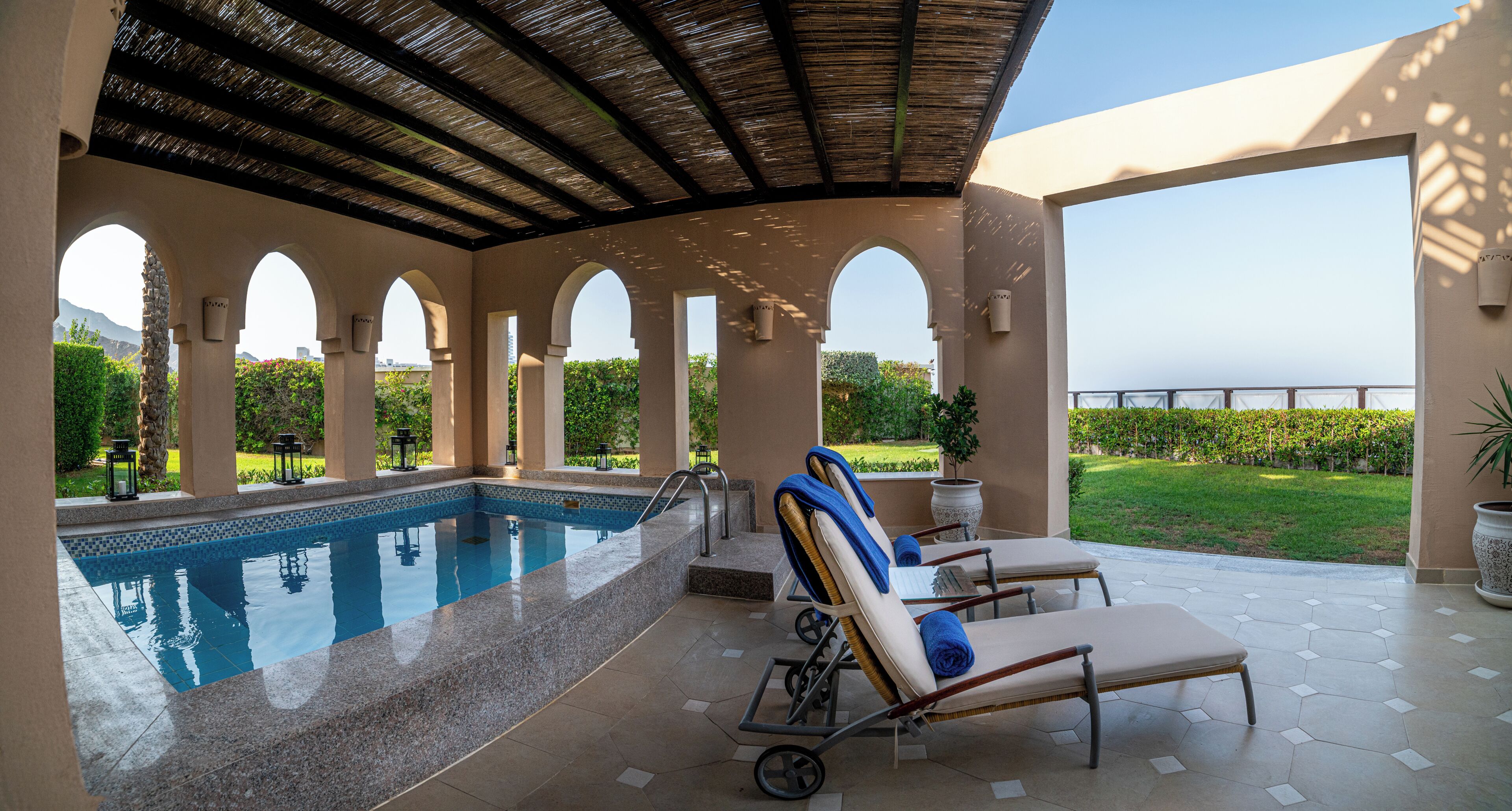 A pool area with a clear view of the surrounding landscape, including a distant mountain and well-maintained greenery.