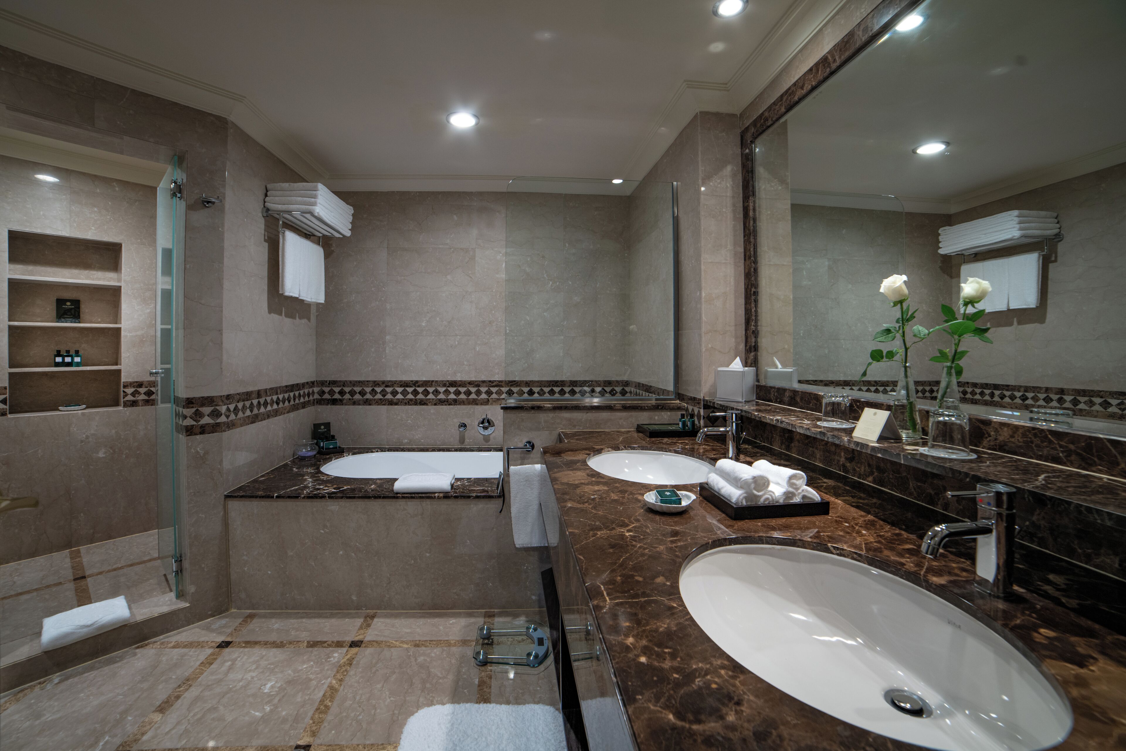 Une salle de bain moderne avec une baignoire, deux lavabos et un grand miroir.