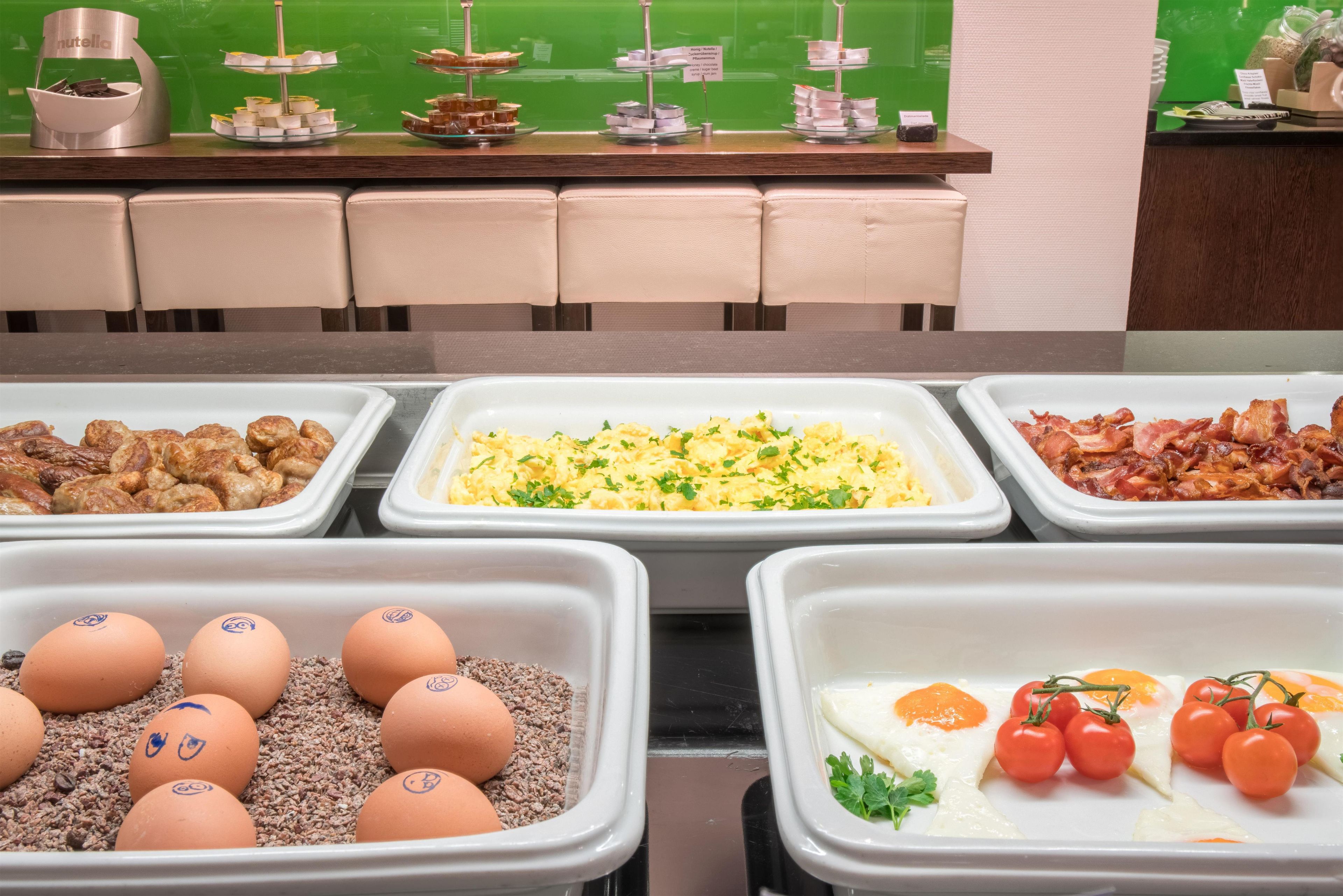 A buffet with various food options including eggs, bacon, and scrambled eggs.