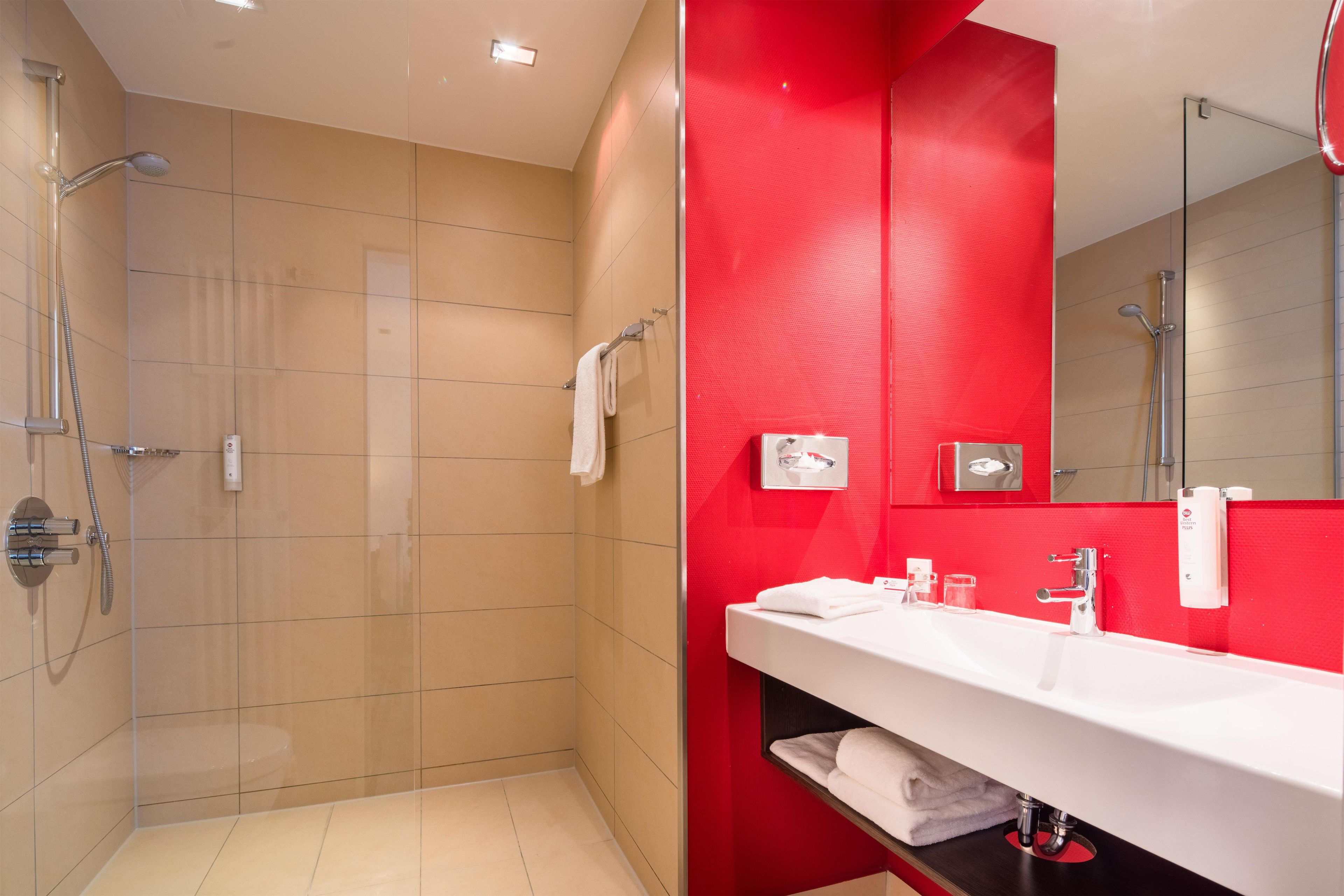 Une salle de bain moderne avec une douche, un lavabo et un miroir.
