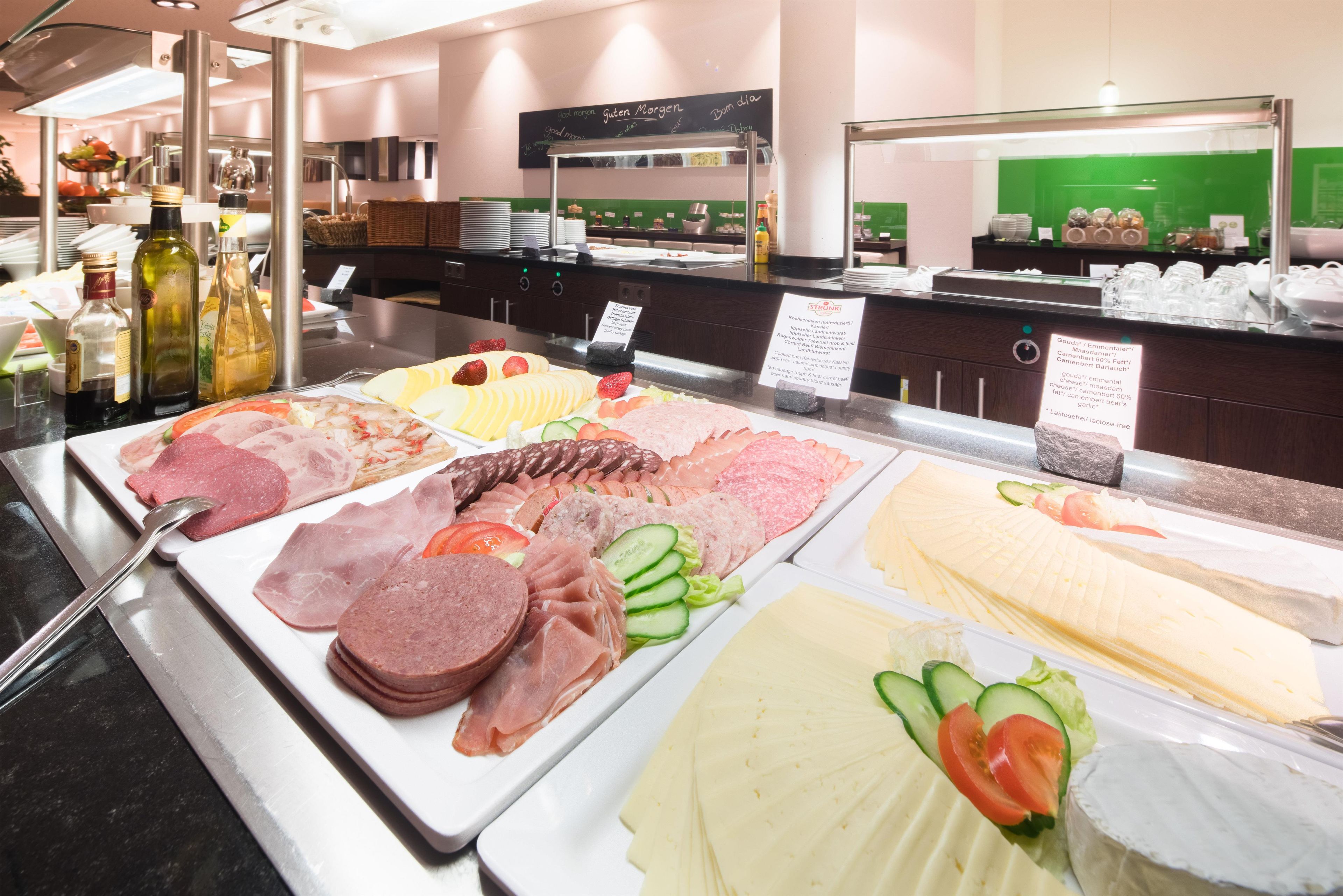 A buffet with various meats, cheeses, and vegetables.