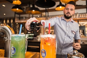 Un barman verse une boisson dans un verre muni d’une paille.