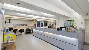 A modern reception area with a counter, office chairs, a display of ice cream, and a large framed picture on the wall.