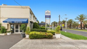 A motel reception with a sign for Alexander Motor Inn & Apartments.