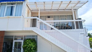 A two-story building with a balcony, a staircase, and a door.