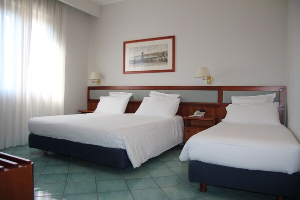 A hotel room with two beds, a wooden headboard, two bedside tables with lamps, and a framed picture on the wall. - Hotel Marad (Torre del Greco)