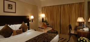 A hotel room with a large bed, two bedside tables with lamps, a desk with a telephone, and a chair. - Fortune Select Exotica, Navi Mumbai - Member ITC Hotels' Group (Navi Mumbai)