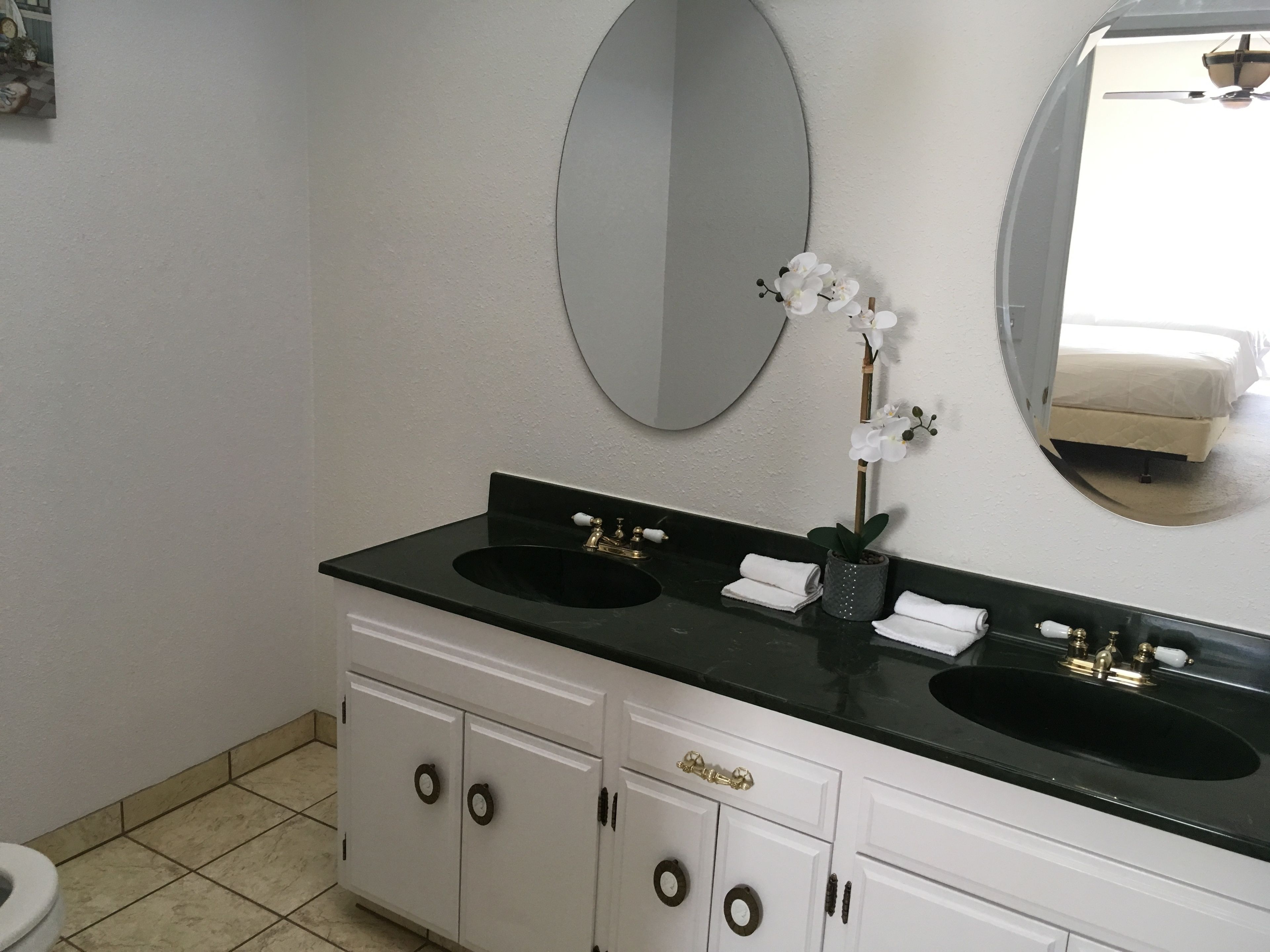 A bathroom with two sinks, a mirror, and a toilet.