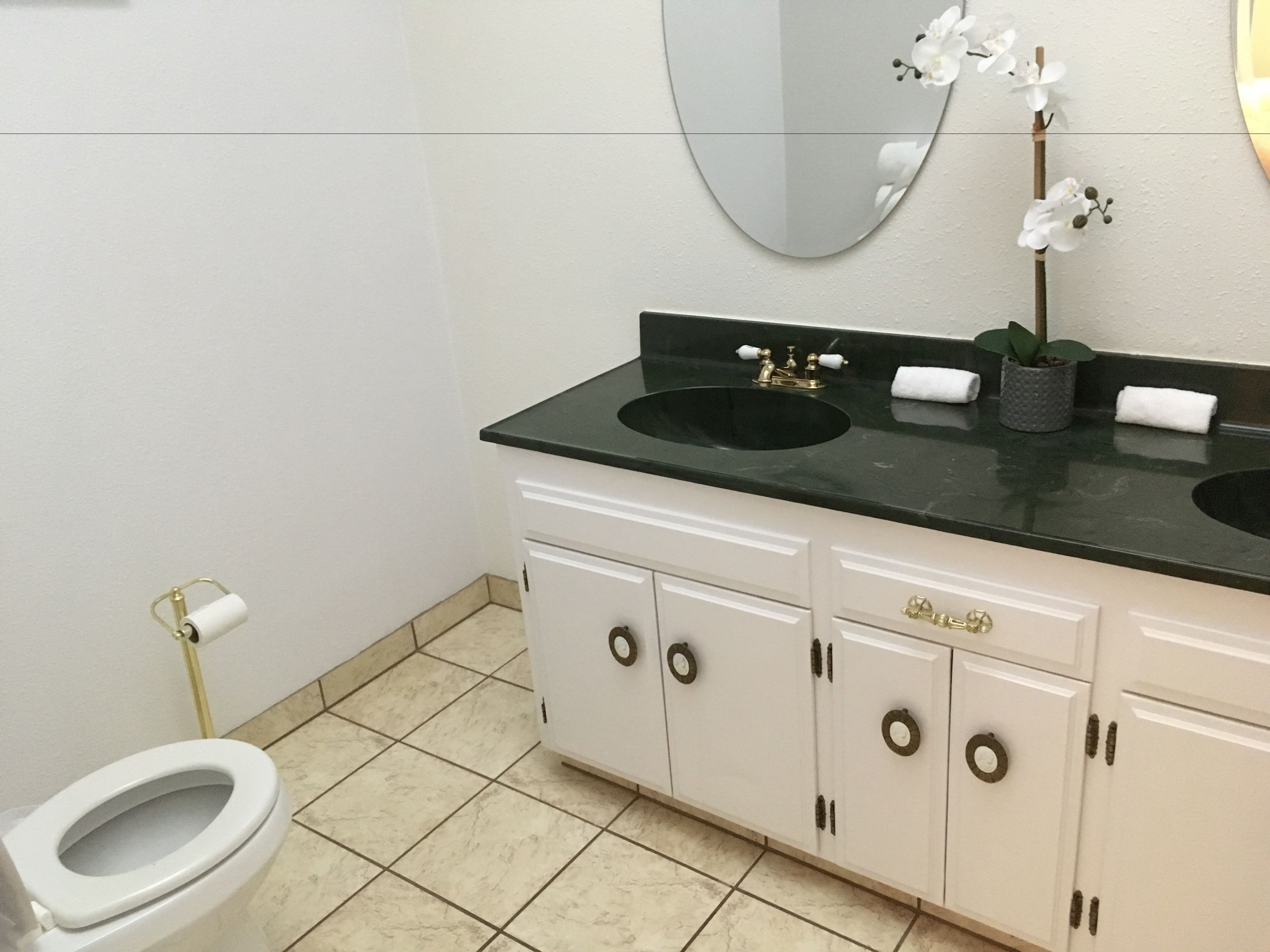 Un baño con dos lavamanos, un inodoro y un espejo.