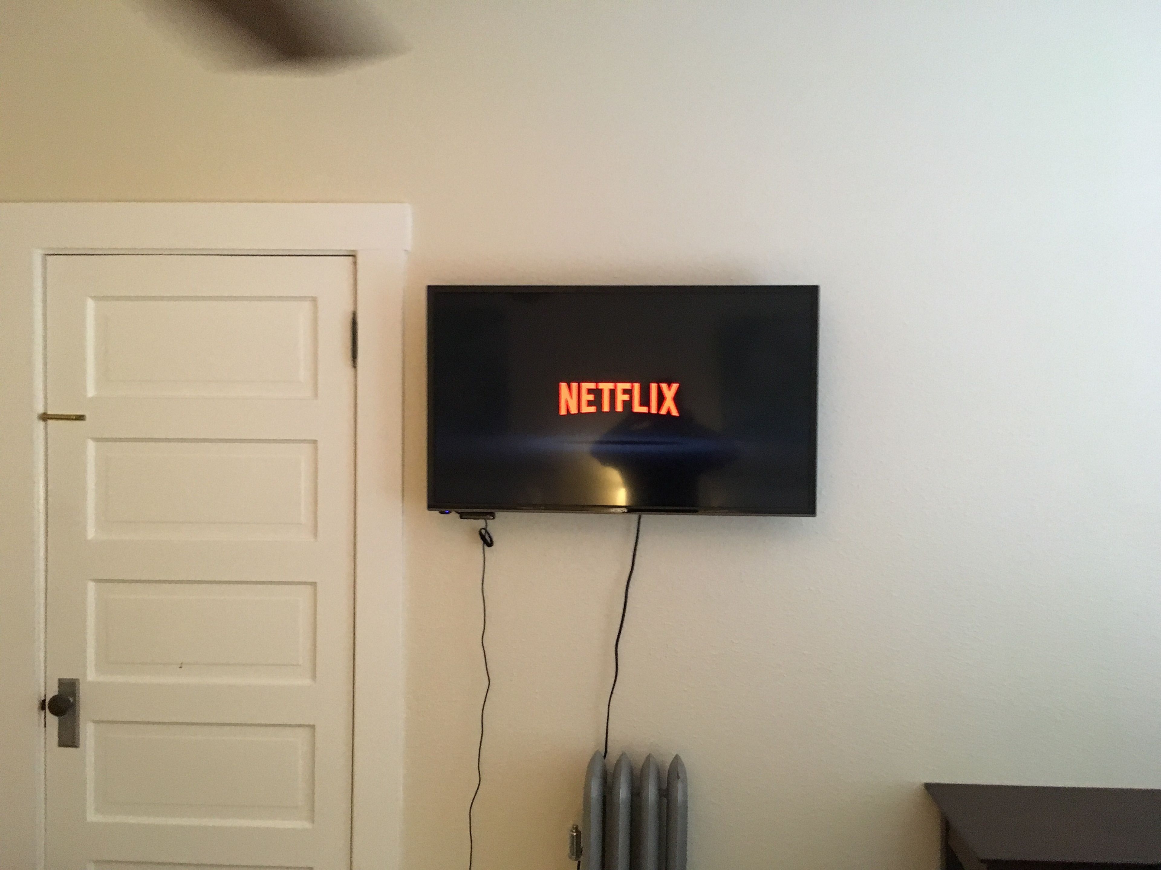 Seinälle asennettu televisio, jonka näytöllä näkyy Netflixin logo.