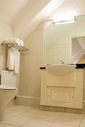 Un baño con inodoro, lavabo y toallero.