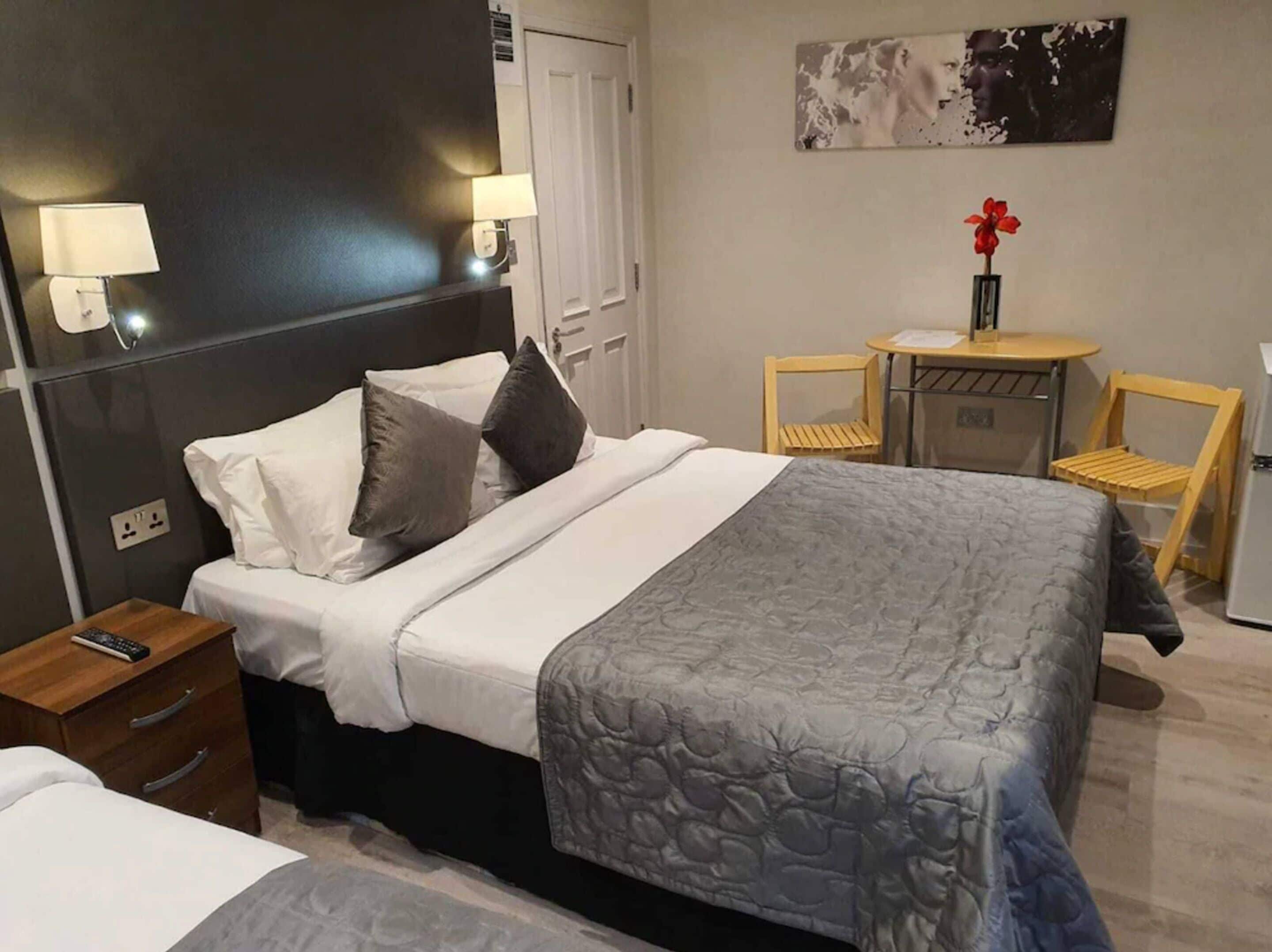 Ein Hotelzimmer mit Bett, Nachttischen, Schreibtisch und Stuhl.