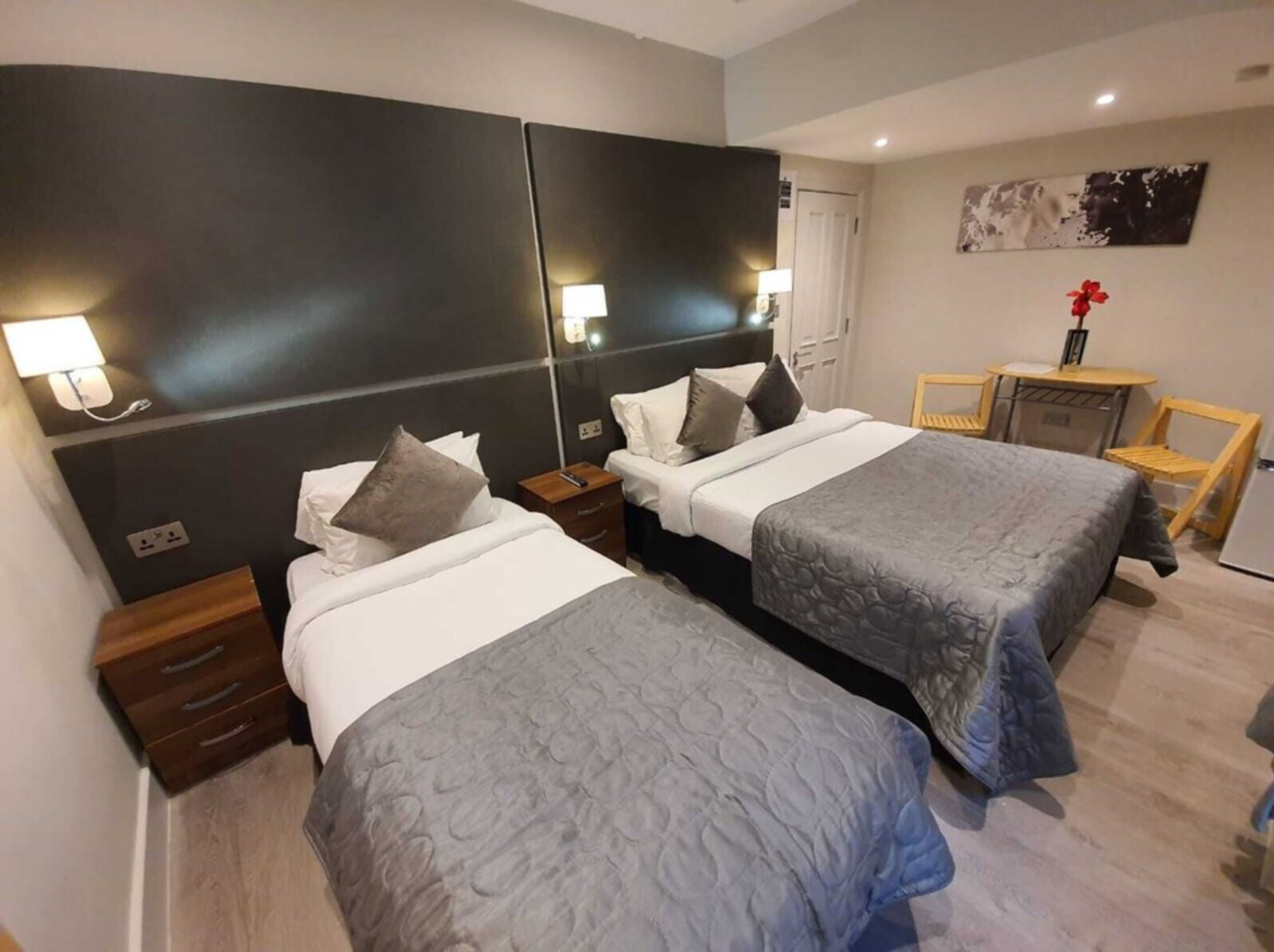 Une chambre d’hôtel avec deux lits, un bureau et une chaise.