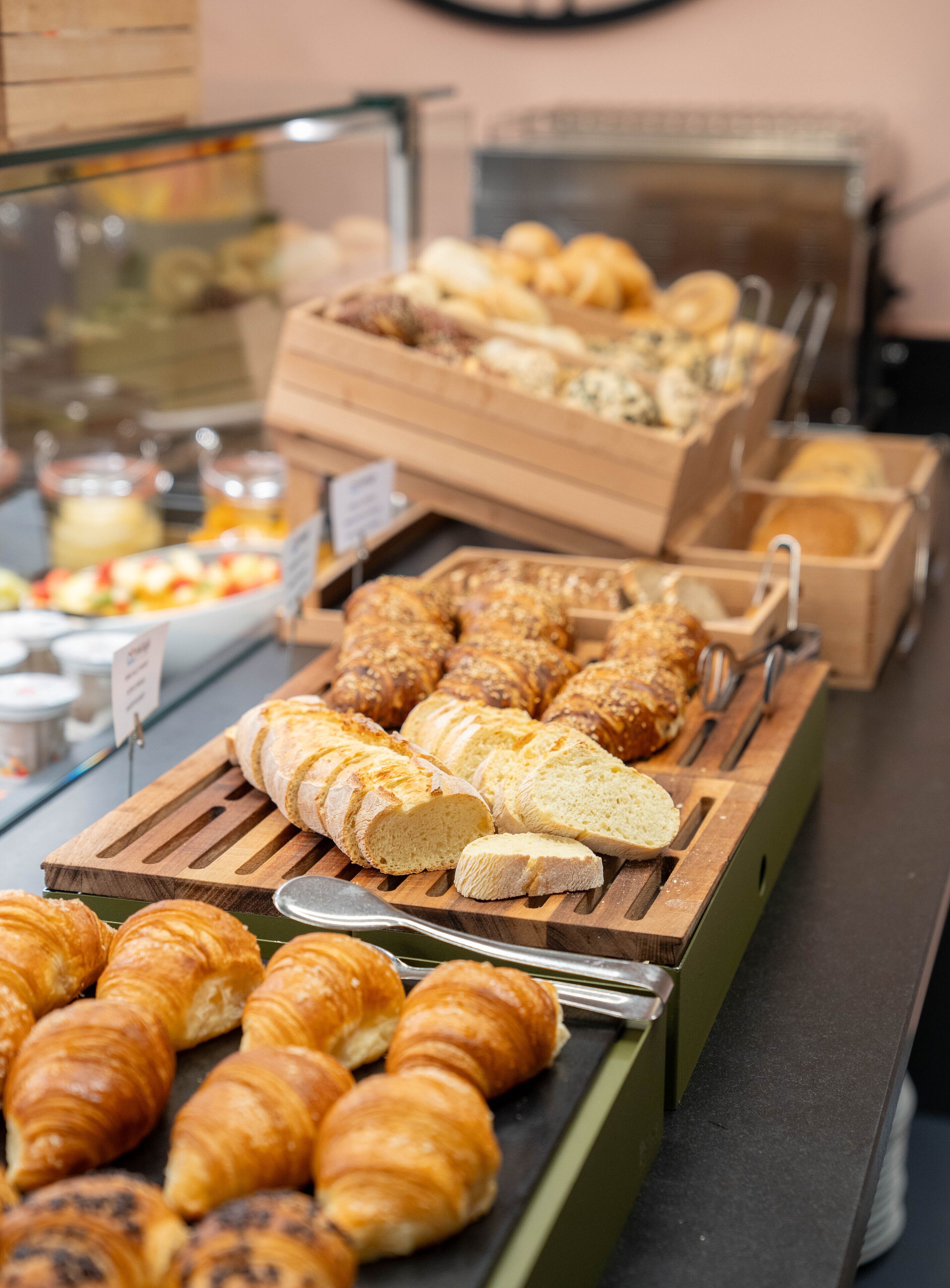 Une vitrine de boulangerie présentant divers produits de boulangerie, notamment du pain, des croissants et des pâtisseries.