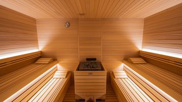 Una sauna con bancos de madera y una unidad de calefacción central.