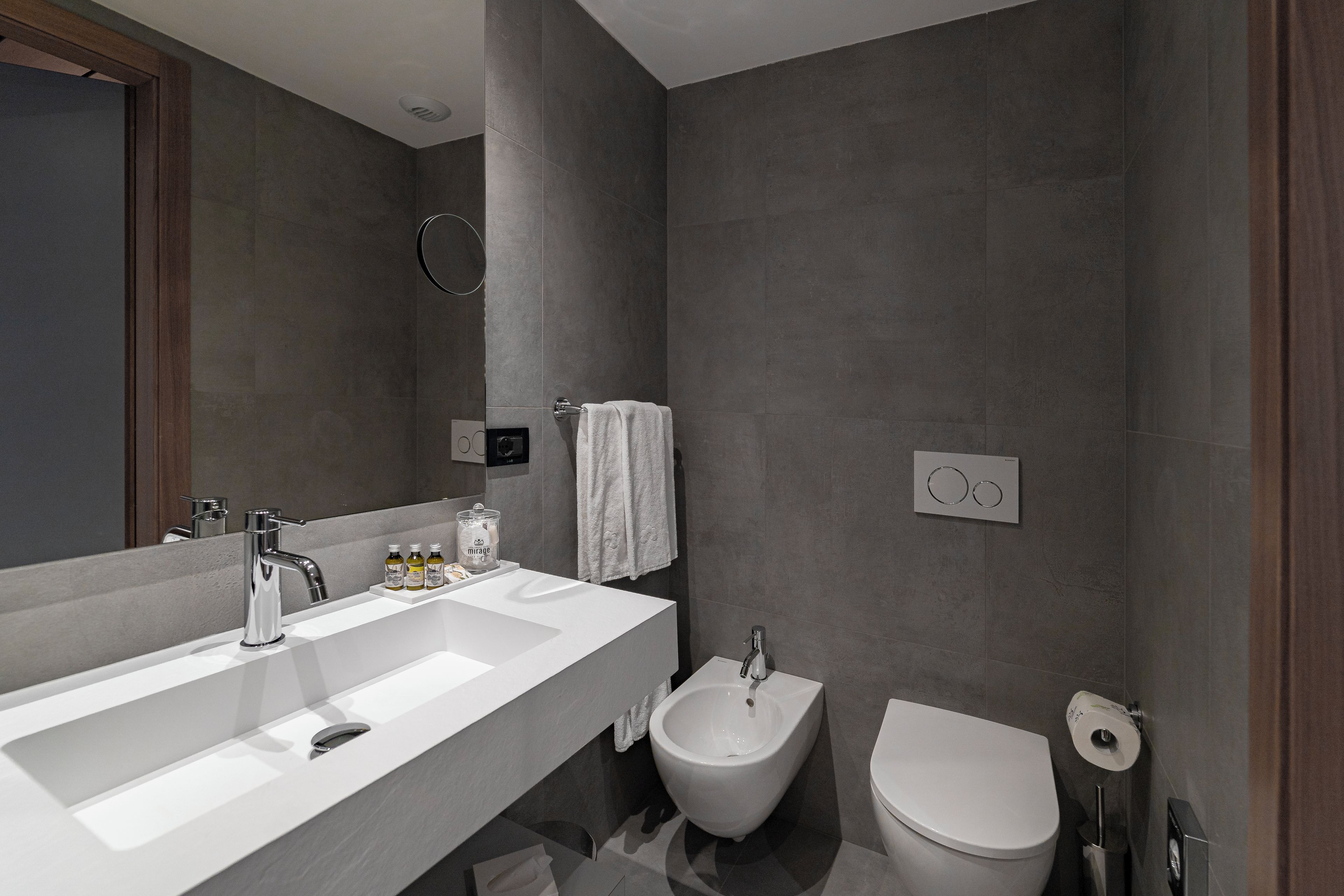 Un baño moderno con un lavamanos espacioso, un bidé y un inodoro.
