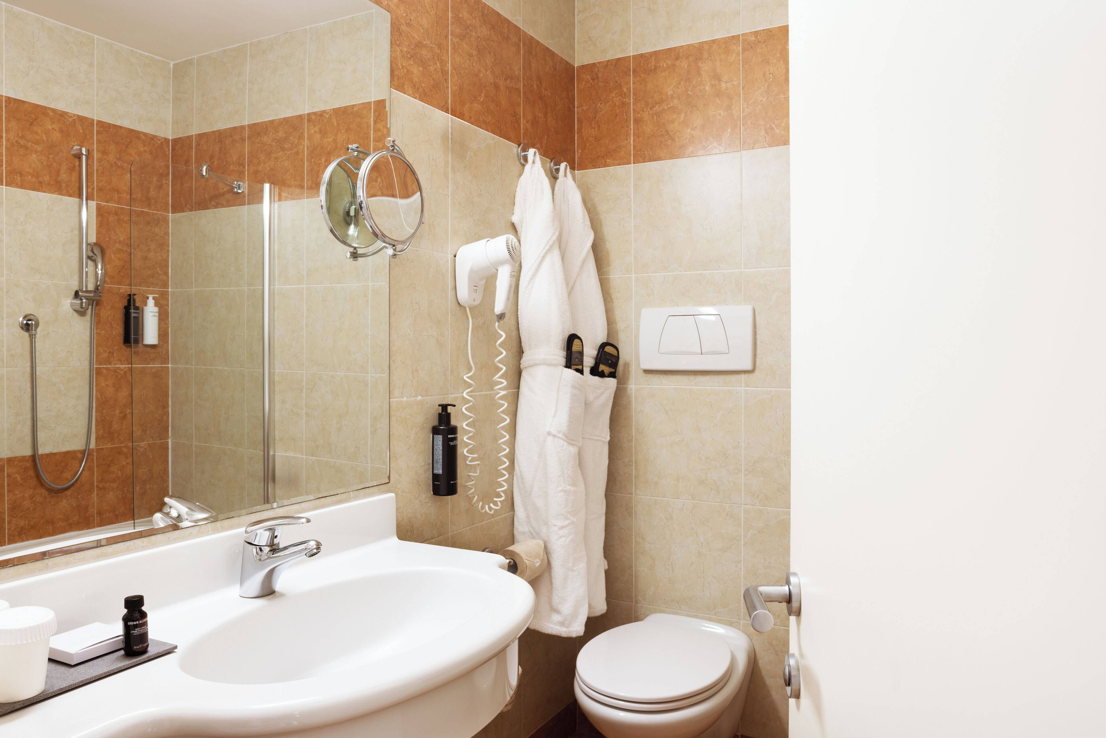 Ein Badezimmer mit Waschbecken, Spiegel, Dusche und Toilette.