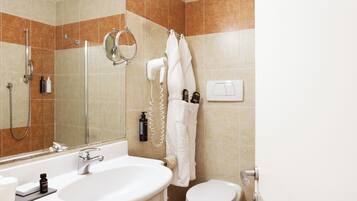 Ein Badezimmer mit Waschbecken, Spiegel, Dusche und Toilette.