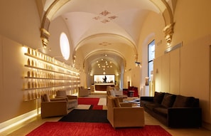 A spacious lobby with a bar area, seating arrangements, and a decorative ceiling.