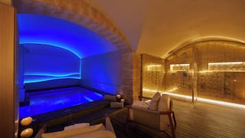 Un área de spa con piscina climatizada, asientos y piso de madera.