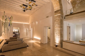 Eine Hotelhalle mit modernem Design, inklusive einer Couch, einer Rezeption und einer Treppe.