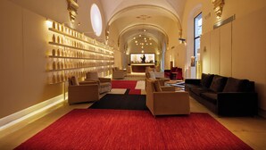 A spacious lobby with a red carpet, sofas, and a bar area. - Convent de la Missio Boutique Hotel GL, Adults Only – Preferred Hotels & Resorts (Palma de Mallorca)