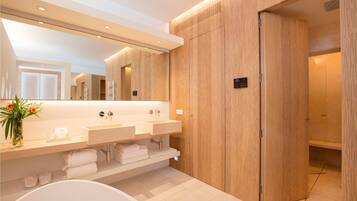 A modern bathroom with a large mirror, two sinks, a bathtub, and wooden paneling.