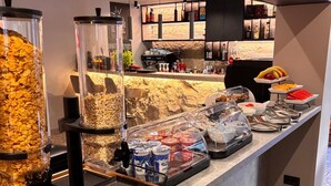 A buffet area with various food items, including cereal, yogurt, and canned goods. - Hotel Aquarius Adults Only (Dubrovnik)