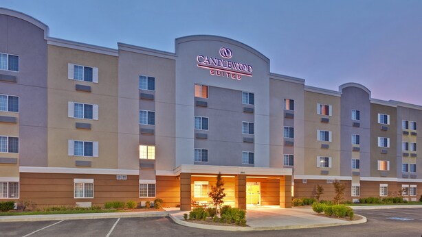 Ein mehrstöckiges Hotel mit einem gut sichtbaren Schild, auf dem 'Candlewood Suites' steht.