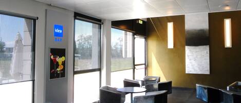 A modern bar area with seating and a large window.