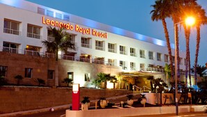 The exterior of the Leonardo Royal Resort with a prominent entrance, palm trees, and a well-lit facade. - Leonardo Royal Resort Hotel Eilat (Eilat)