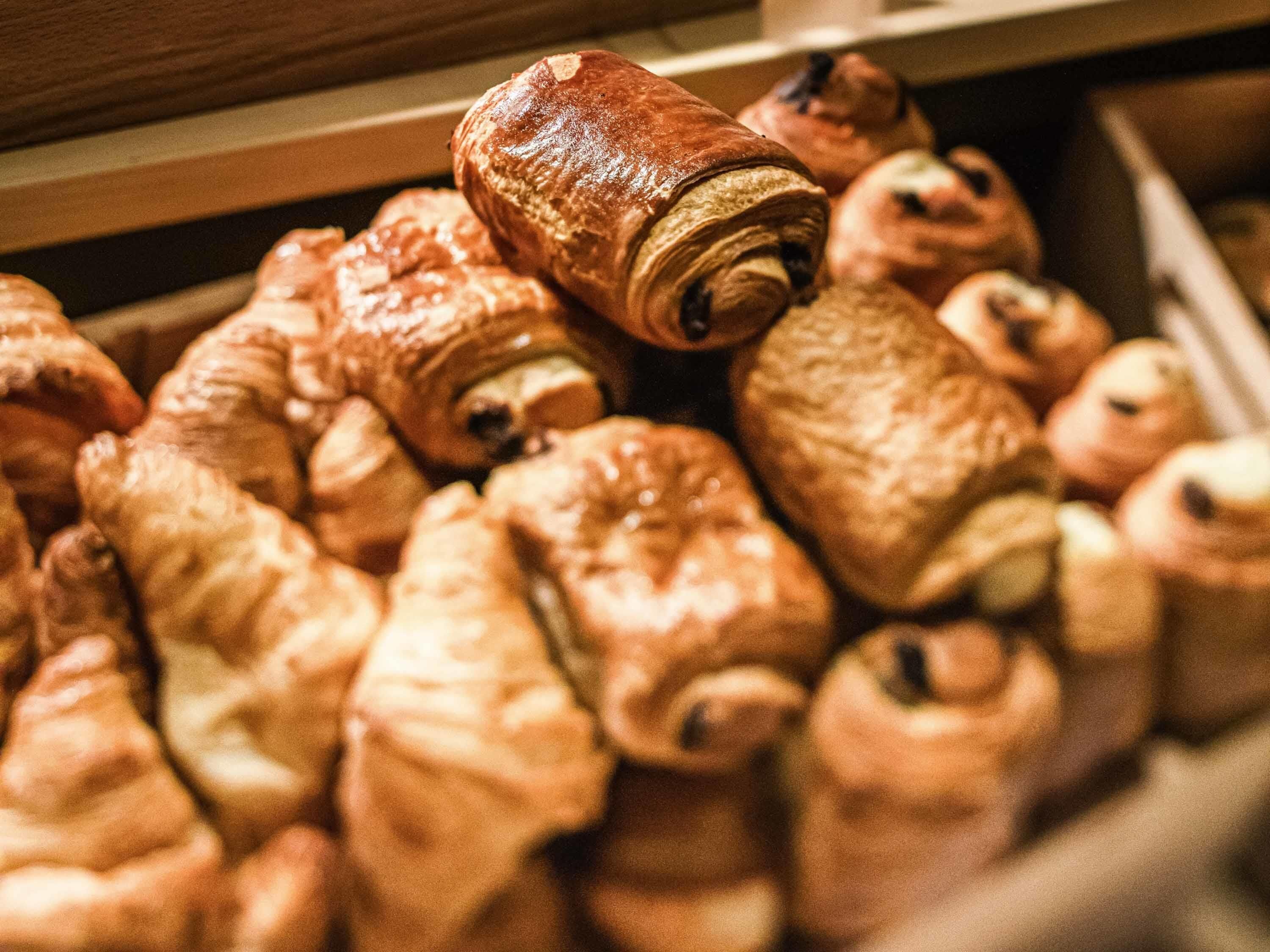 A drawer filled with various pastries, including croissants and other baked goods.