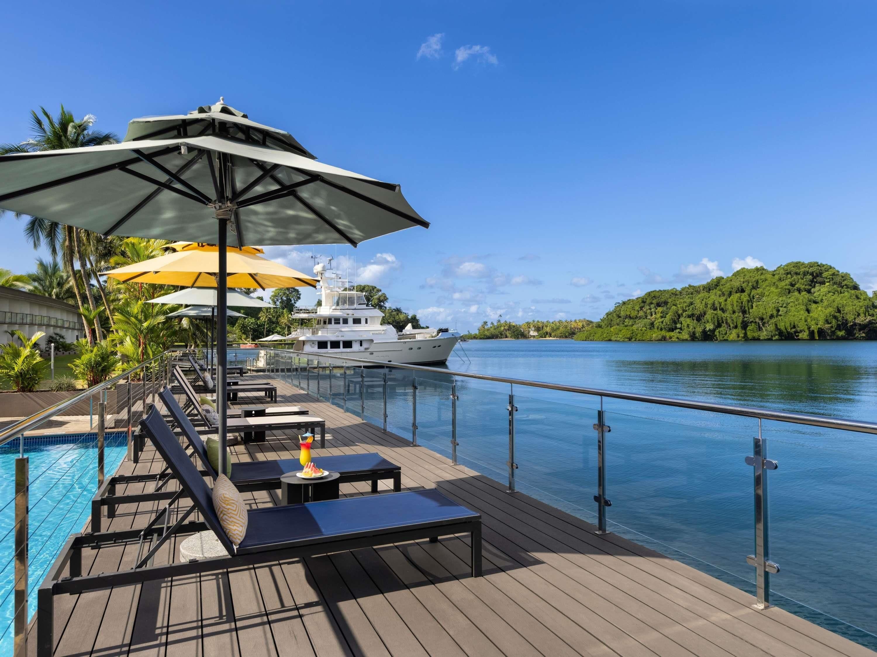 Een buitenzwembad, parasols bij het zwembad en ligstoelen