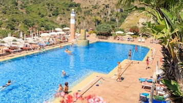 Una piscina techada, una piscina al aire libre de temporada, sombrillas