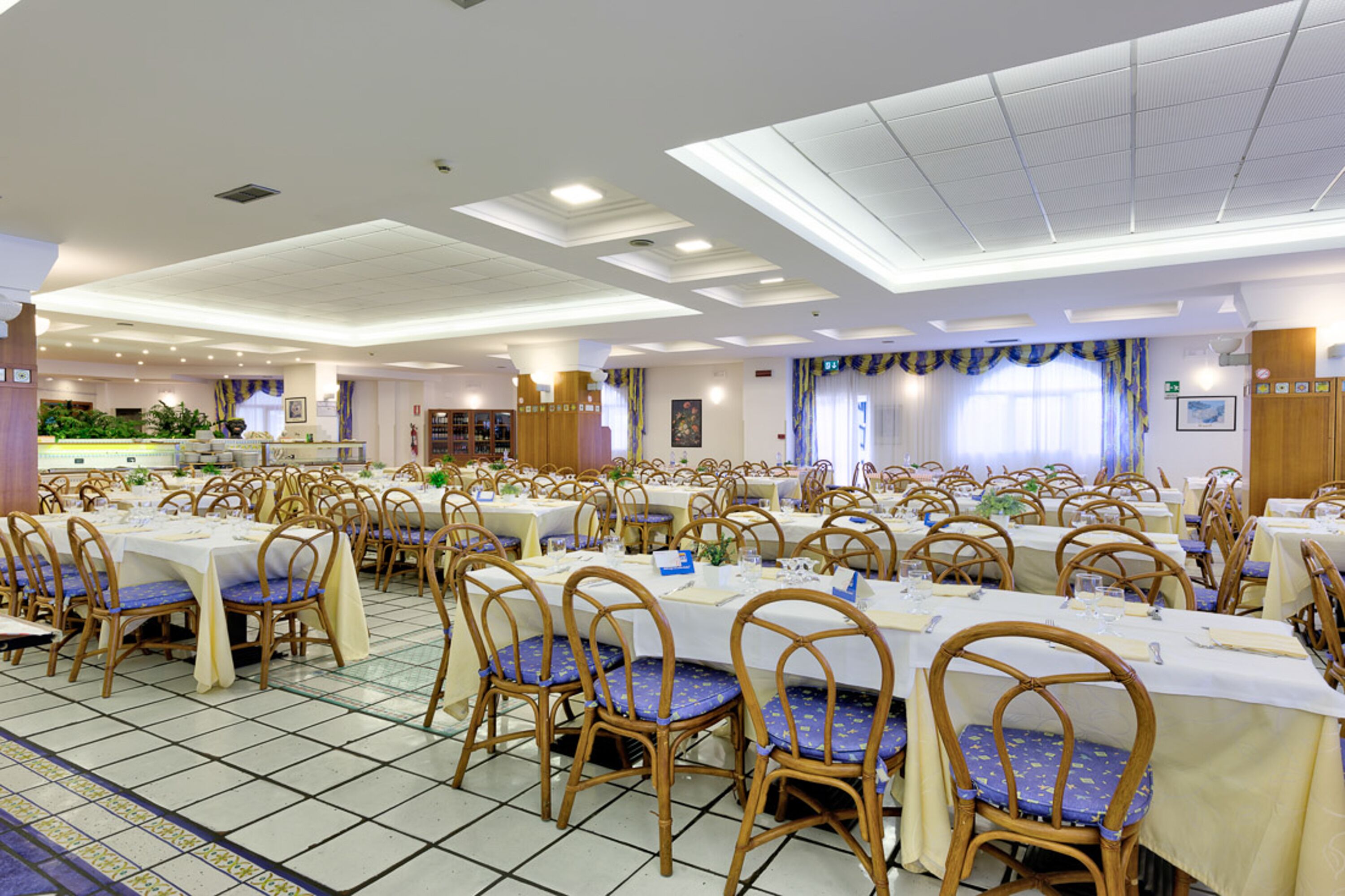 A large banquet hall with multiple tables and chairs, arranged in rows.