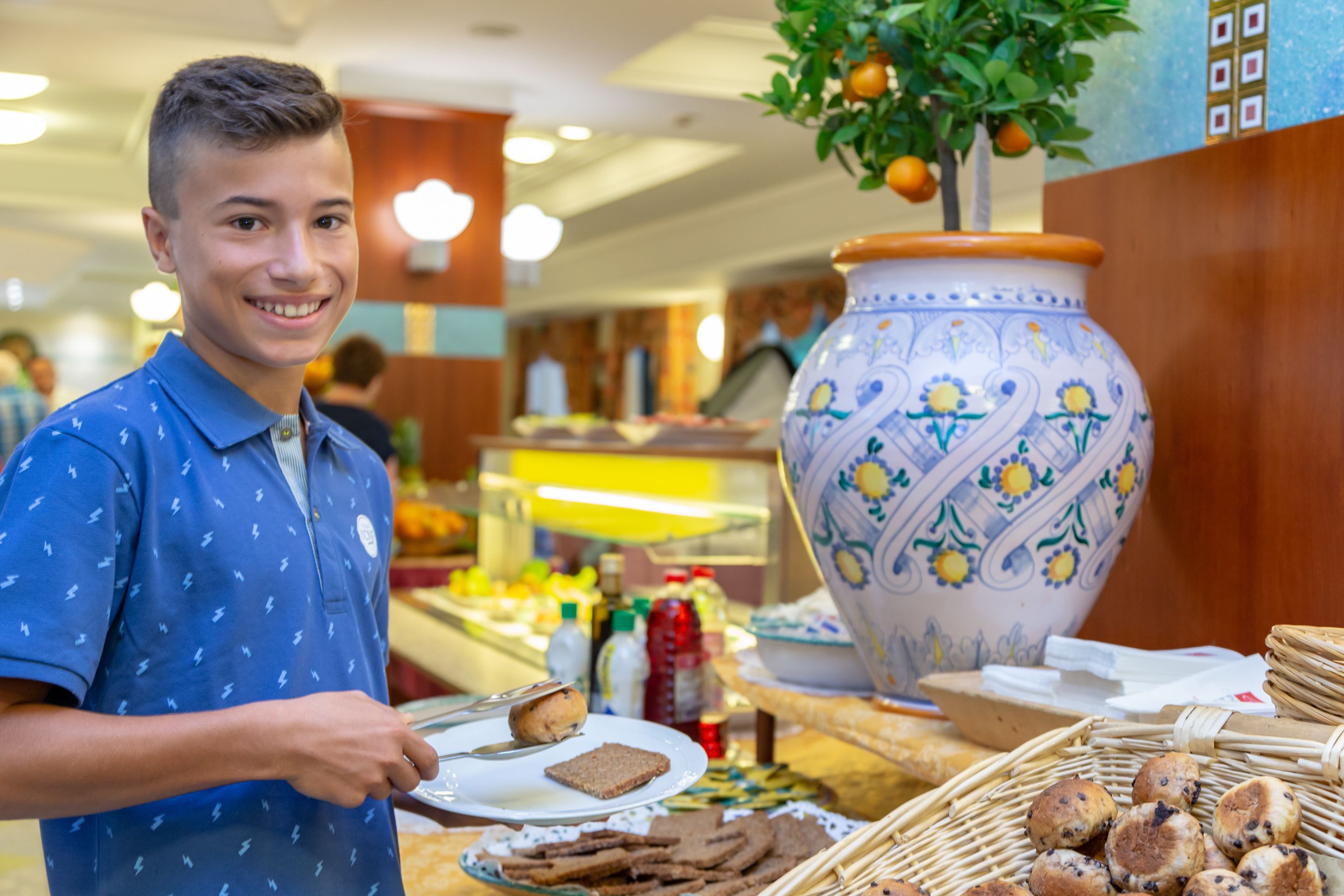Un espace buffet proposant une variété de plats, un grand vase décoratif et une personne qui sert les aliments.