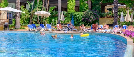 Una piscina al aire libre, tumbonas