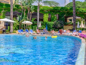 A pool area with lounge chairs and umbrellas. - Hotel Caesar Palace (Giardini Naxos)