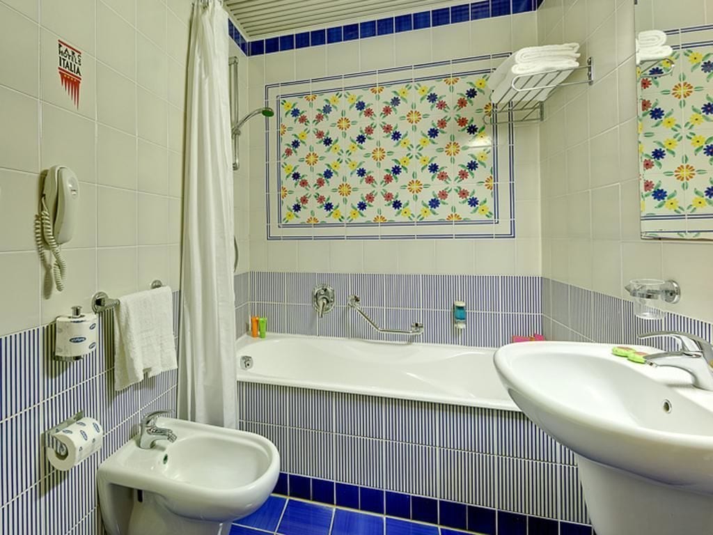 A bathroom with a bathtub, two sinks, a shower, and a toilet.