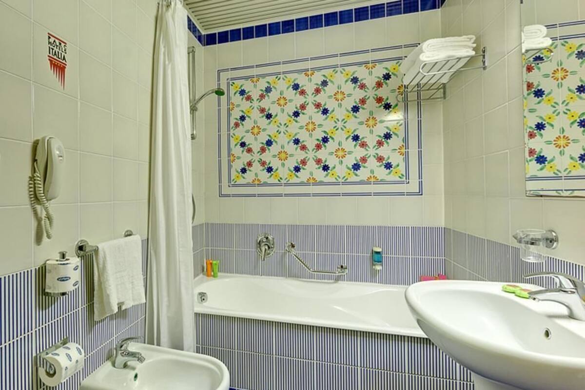 Une salle de bain avec une baignoire, deux lavabos, une douche et des toilettes.
