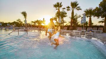 Zona de piscina con sillas de descanso y palmeras, evocando un ambiente de resort.