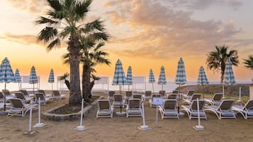 Sulla spiaggia, lettini da mare, ombrelloni, pallavolo