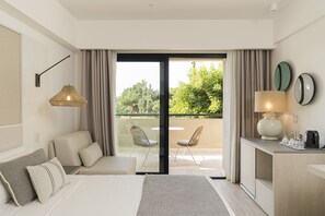 A modern hotel room with a bed, a sofa, a desk, and a balcony with chairs. - Grand Palladium Sicilia Resort & Spa  (Campofelice di Roccella)