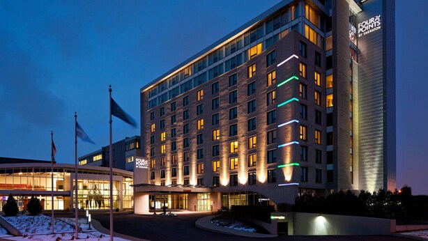 A modern hotel with a large glass facade, multiple floors, and a prominent signage for 'Four Points by Sheraton'. - Four Points by Sheraton Levis Convention Centre (Levis)