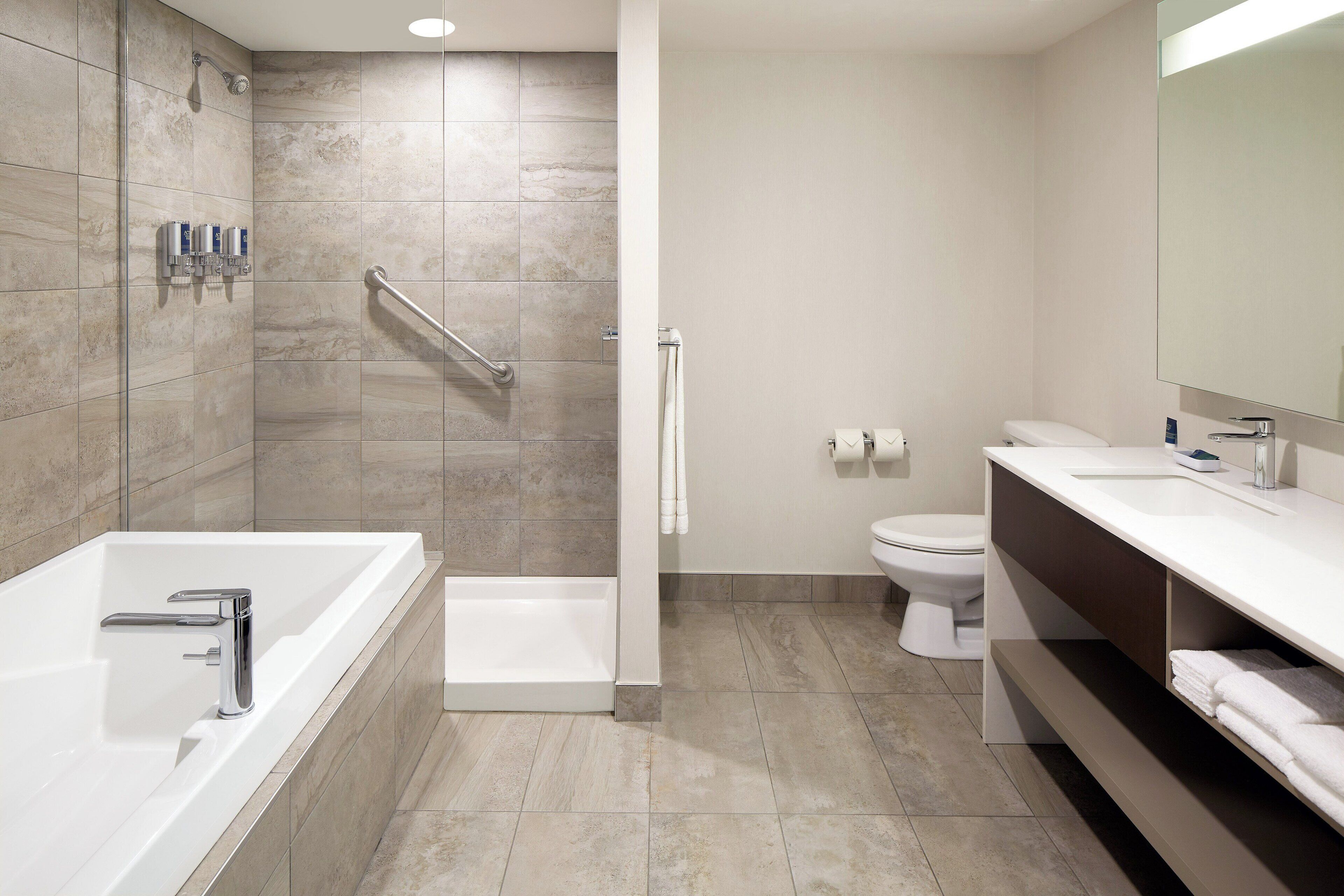 Un baño moderno con bañera, ducha, inodoro y tocador.
