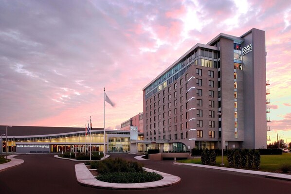 A modern hotel with a prominent 'Four Points by Sheraton' sign, a well-lit entrance, and a landscaped driveway. - Four Points by Sheraton Levis Convention Centre (Levis)